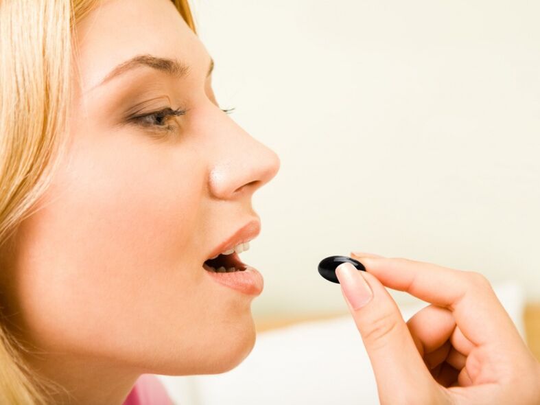 a girl takes a pill to prevent worms